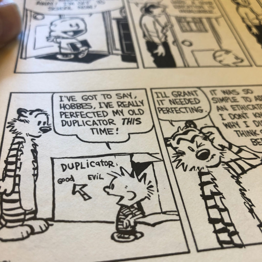 Photograph of a page of Calvin and Hobbes. Calvin is showing Hobbes his homemade cardboard Duplicator box.